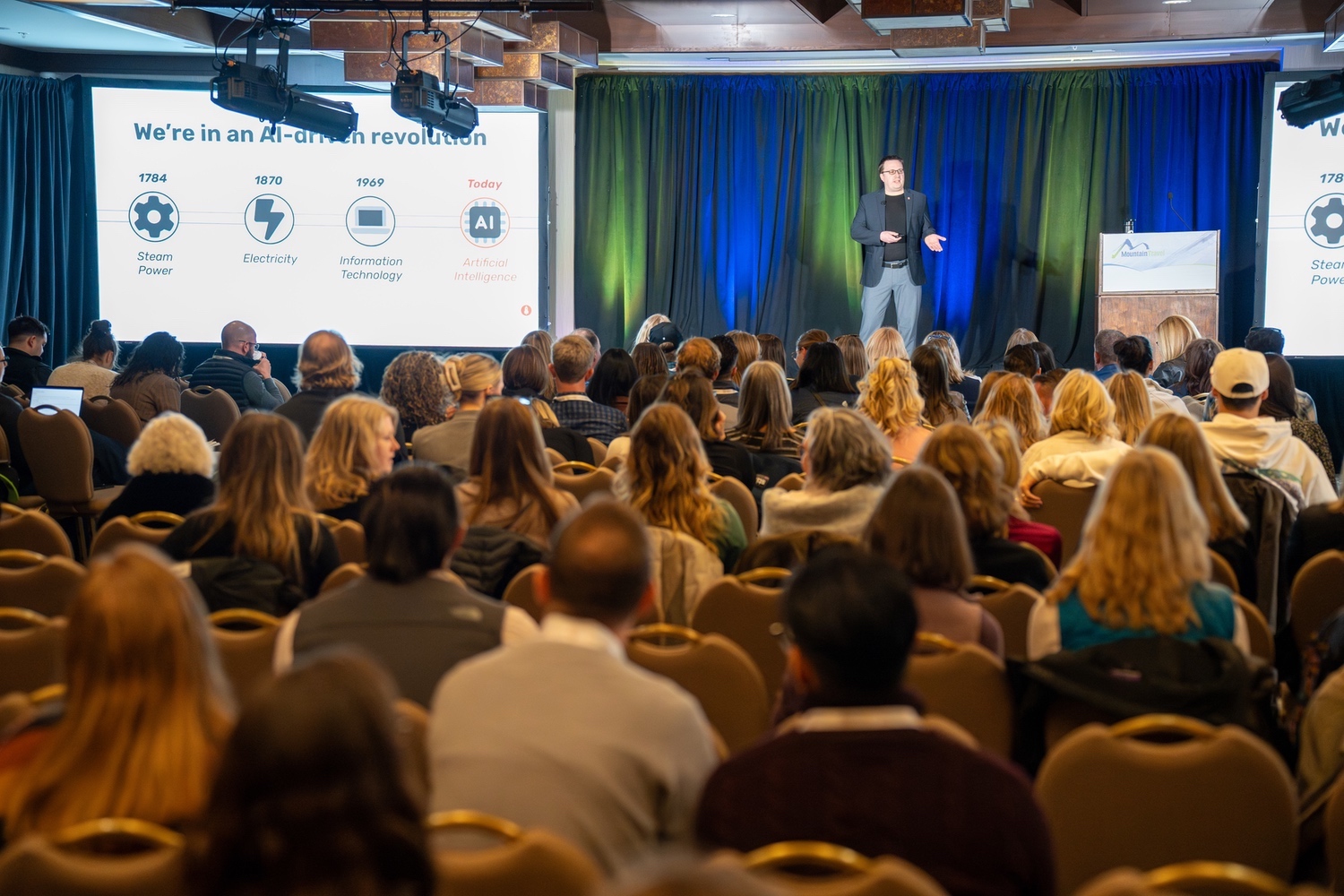 Speaker presents on AI revolution to an audience at a conference event.
